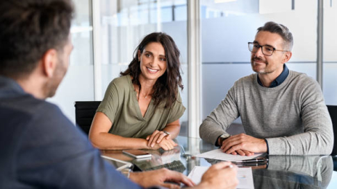Conseiller accompagnant un couple pour choisir un courtier immobilier